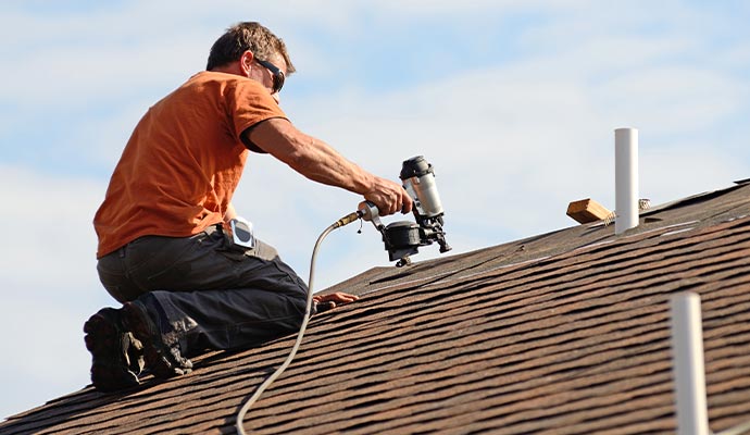 Person installing roof on a house